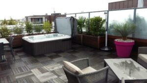 A Hot Tub On A Patio With Glass Panels As A Hot Tub Enclosure